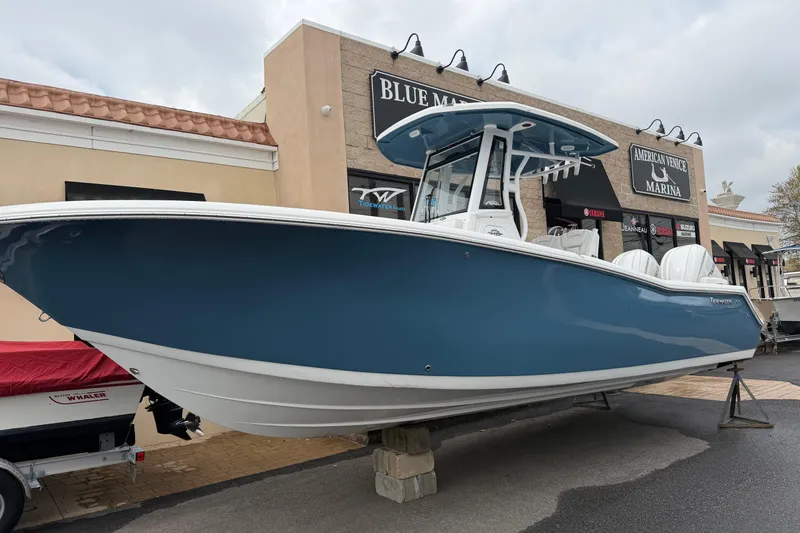 The Image of 2026 Tidewater 272 LXF boat displayed at marina, featuring sleek blue hull design. - 1