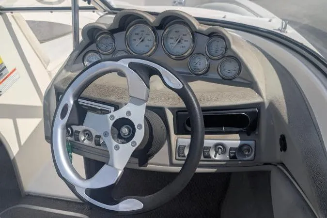 Slide: The Image of Steering wheel and dashboard of a 2010 Bayliner 185 Bowrider boat. - 2