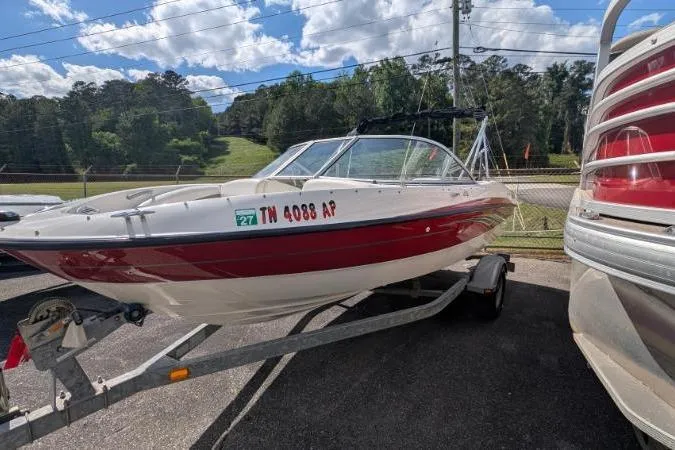 Slide: The Image of 2010 Bayliner 185 Bowrider boat on trailer, parked outdoors under a partly cloudy sky. - 8