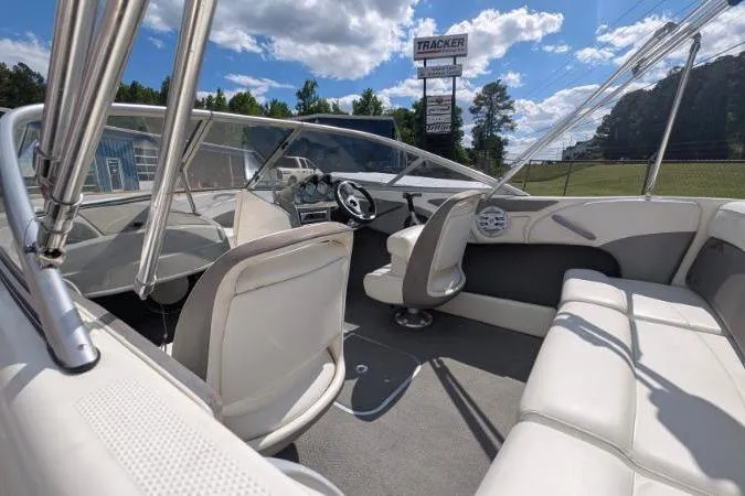 Slide: The Image of 2010 Bayliner 185 Bowrider interior with white seating, steering wheel, and clear skies. - 9