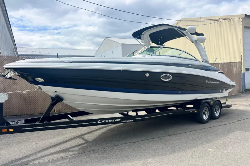 The Image of 2018 Crownline 285 SS boat on trailer, parked outdoors under cloudy sky. - 0