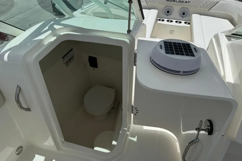 Slide: The Image of Interior view of 2026 World Cat 230 SD boat's compact bathroom with solar vent. - 10