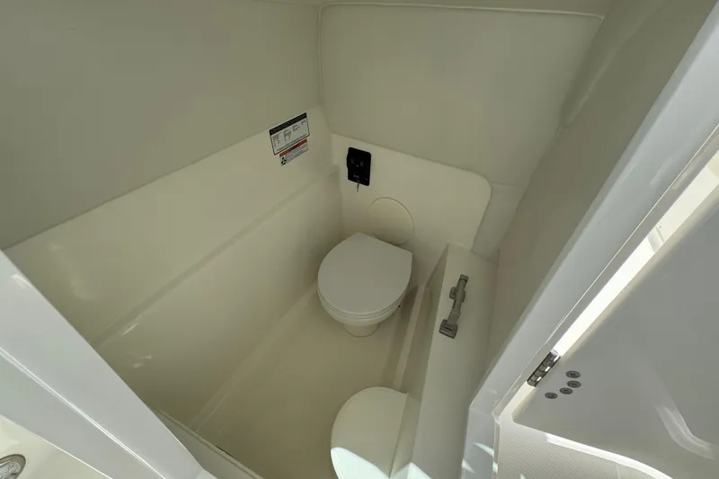Slide: The Image of Interior of 2026 World Cat 230 SD boat bathroom, featuring a compact toilet. - 11