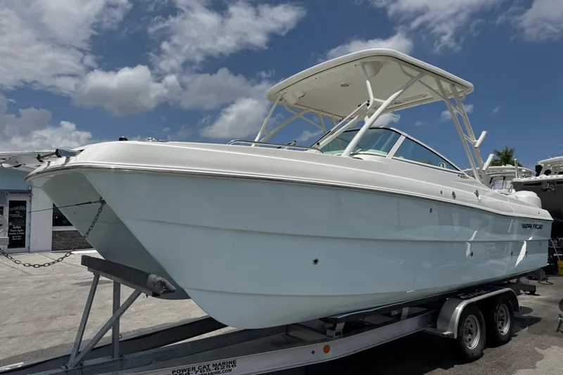 Slide: The Image of 2026 World Cat 230 SD boat on trailer under clear blue sky. - 2