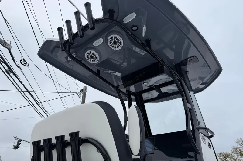 Slide: The Image of 2026 Tidewater 256 LXF boat with sleek T-top and rod holders, viewed from below. - 6