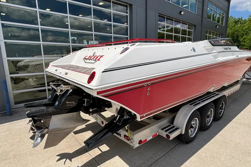 Slide: The Image of 2007 Fountain 42 Lightning speedboat with red and white design on a trailer outside a building. - 12