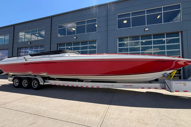Slide: The Image of 2007 Fountain 42 Lightning speedboat in red on a trailer outside a modern building. - 42