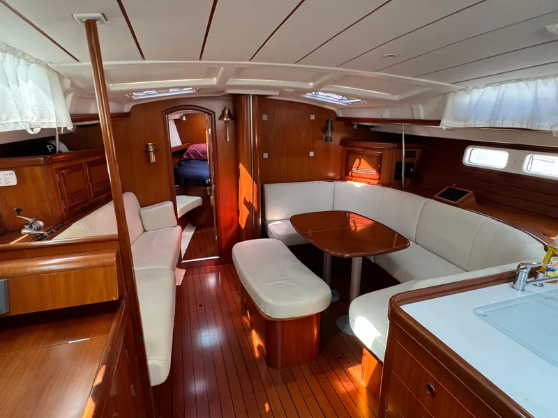 Slide: The Image of Interior of 2001 Beneteau Oceanis Clipper 473 yacht with wooden finish and white seating. - 14