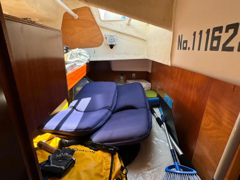 Slide: The Image of Interior cabin of 2001 Beneteau Oceanis Clipper 473 with cushions and cleaning supplies. - 30