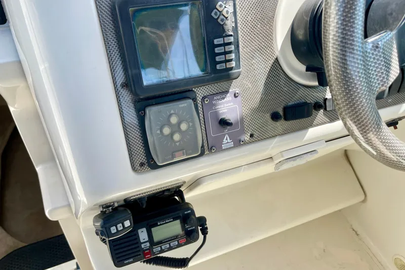 Slide: The Image of Control panel of a 2000 Monterey 302 Cruiser boat with steering wheel and navigation equipment. - 11