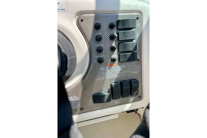 Slide: The Image of Control panel of a 2000 Monterey 302 Cruiser boat with switches and buttons. - 12