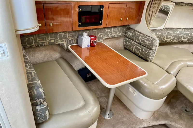 Slide: The Image of Interior of a 2000 Monterey 302 Cruiser with seating and a wooden table. - 19