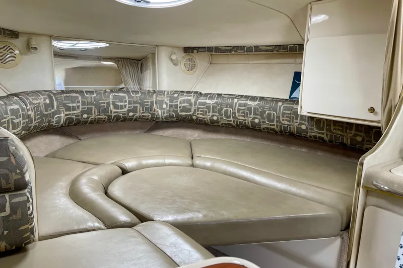 Slide: The Image of Interior of a 2000 Monterey 302 Cruiser boat with cushioned seating and storage. - 20