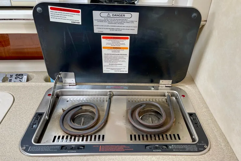 Slide: The Image of Electric stove in a 2000 Monterey 302 Cruiser boat, featuring dual burners and safety instructions. - 23