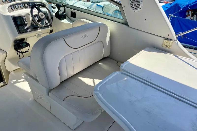 Slide: The Image of Interior of a 2000 Monterey 302 Cruiser boat with white seating and steering console. - 6