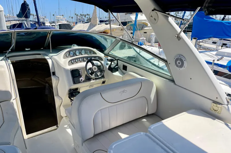 Slide: The Image of 2000 Monterey 302 Cruiser cockpit with steering wheel and gauges, docked at marina. - 8
