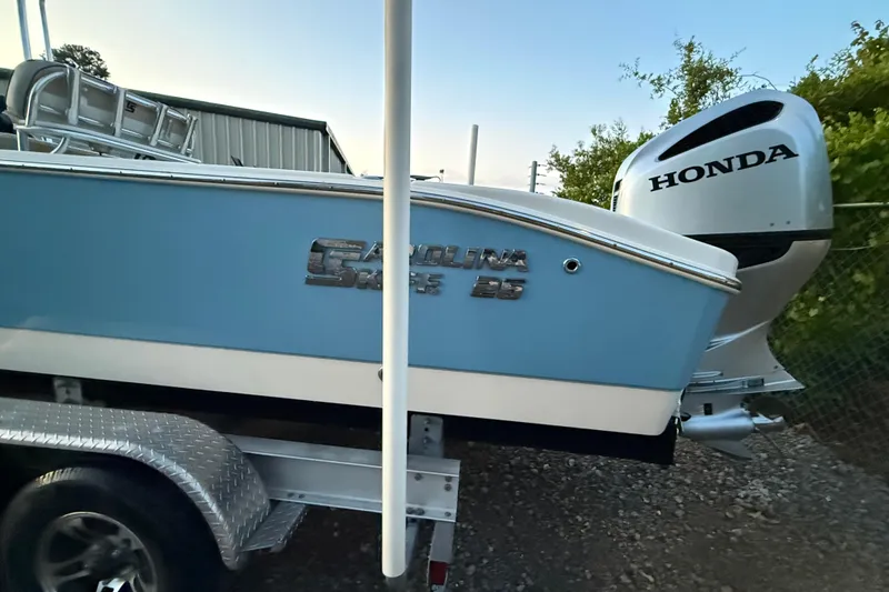 Slide: The Image of 2021 Carolina Skiff 26 Ultra Elite boat with seating and console, parked outdoors. - 14