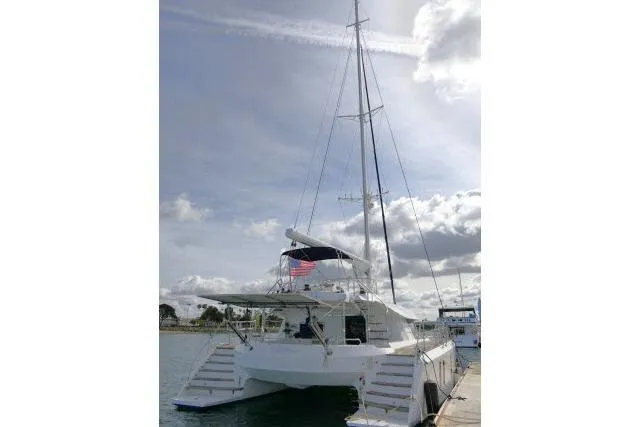 Slide: The Image of 2014 Tayana Isara 50 catamaran docked under a cloudy sky. - 105