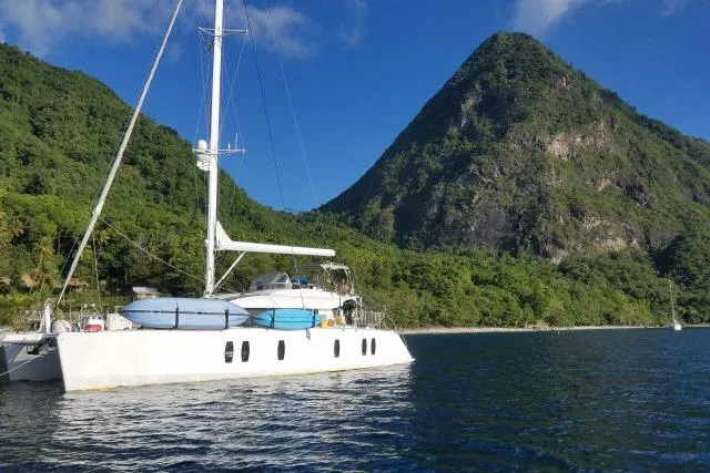 Slide: The Image of Sailing yacht Tayana Isara 50, 2014, anchored near lush mountain landscape. - 107