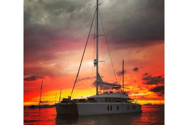 Slide: The Image of Tayana Isara 50 yacht at sunset, 2014 model, silhouetted against vibrant sky. - 108