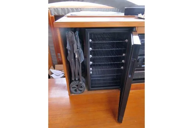 Slide: The Image of Open cabinet with a mini fridge and folded chairs on a 2014 Tayana Isara 50 yacht. - 14