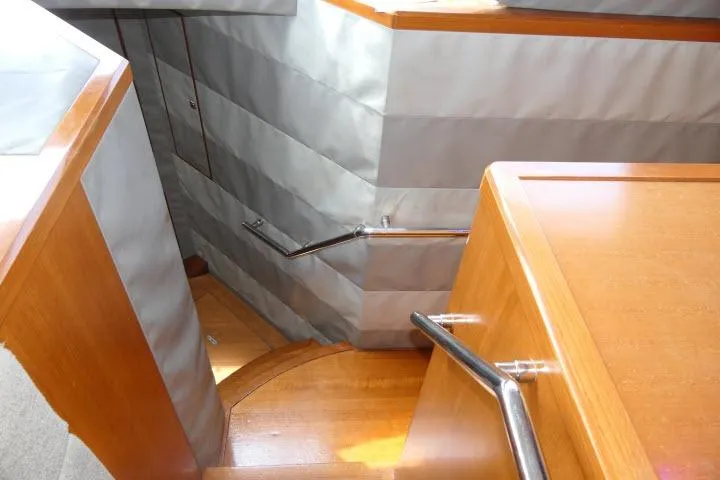 Slide: The Image of Staircase inside 2014 Tayana Isara 50 yacht, featuring wooden steps and sleek metal railings. - 40