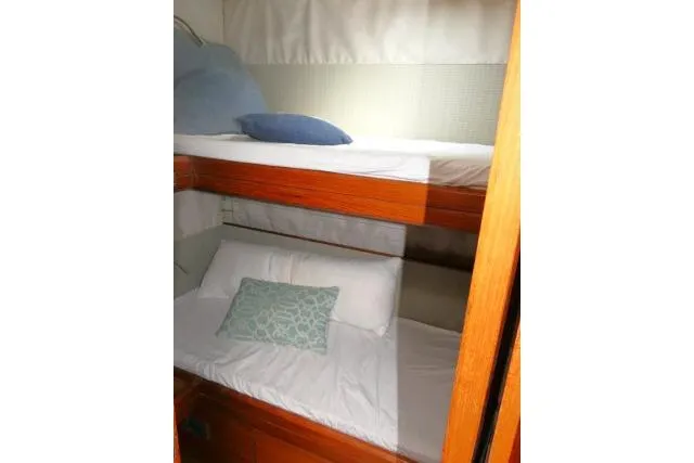 Slide: The Image of Bunk beds in 2014 Tayana Isara 50 yacht cabin with pillows and wooden accents. - 48