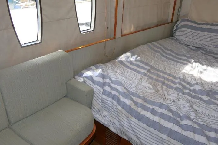 Slide: The Image of Cozy cabin interior of 2014 Tayana Isara 50 yacht with striped bedding and cushioned seating. - 51