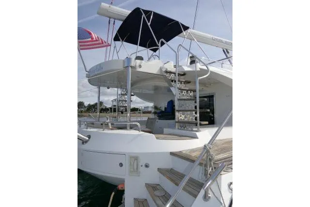 Slide: The Image of 2014 Tayana Isara 50 yacht with American flag, featuring elegant deck and staircase. - 59