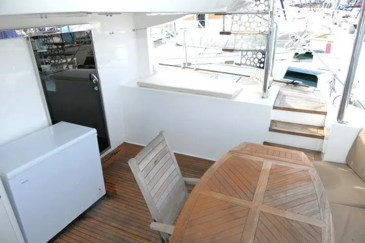 Slide: The Image of 2014 Tayana Isara 50 yacht deck with wooden table and seating area. - 64