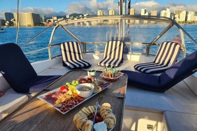 Slide: The Image of Luxurious 2014 Tayana Isara 50 yacht deck with striped seating and gourmet snacks, city skyline view. - 77