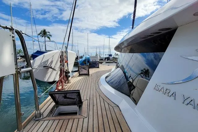 Slide: The Image of 2014 Tayana Isara 50 yacht docked at marina with clear sky and palm trees. - 83