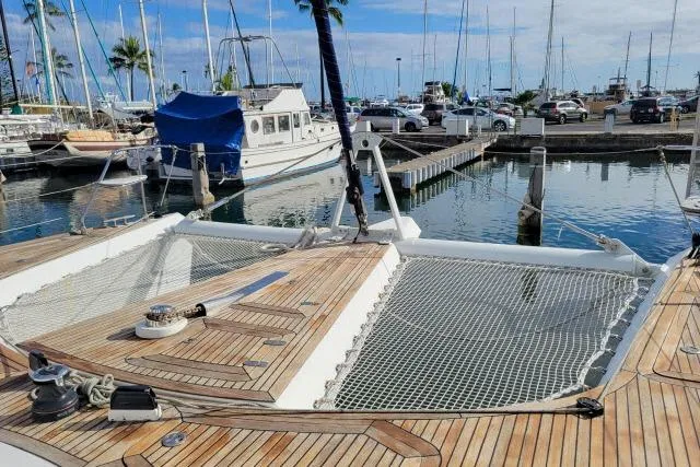 Slide: The Image of 2014 Tayana Isara 50 catamaran docked at a marina with wooden deck and netting. - 85