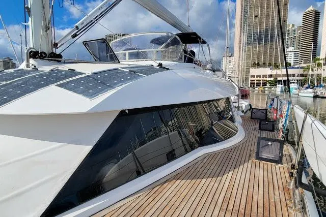Slide: The Image of 2014 Tayana Isara 50 yacht with solar panels, docked in a marina under a blue sky. - 90