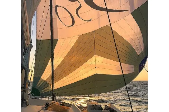 Slide: The Image of Sailing yacht Tayana Isara 50, 2014 model, with colorful sails at sunset on the ocean. - 98