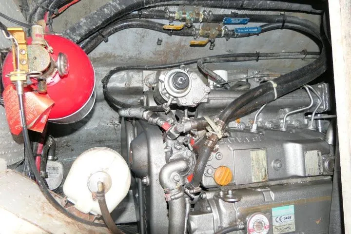 Slide: The Image of Engine compartment of a 2014 Tayana Isara 50 yacht, featuring mechanical components and hoses. - 99