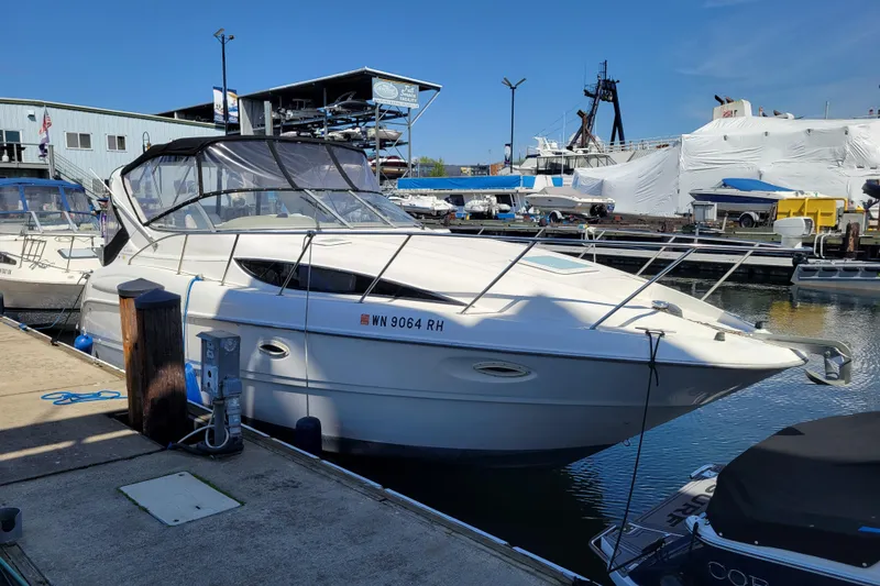 The Image of 1999 Bayliner 3055 Ciera Sunbridge docked at marina under clear blue sky. - 1