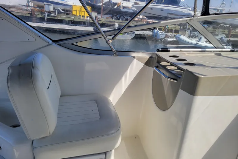 Slide: The Image of 1999 Bayliner 3055 Ciera Sunbridge cockpit with white seating and cup holders. - 12