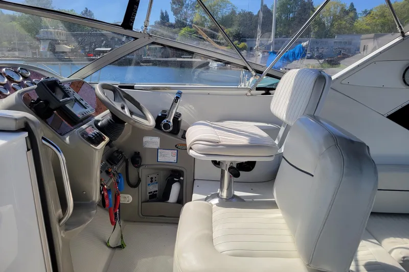 Slide: The Image of Interior of a 1999 Bayliner 3055 Ciera Sunbridge boat, featuring helm and seating. - 13