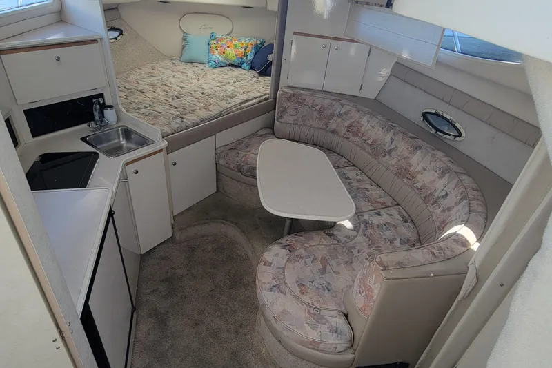 Slide: The Image of Interior of 1999 Bayliner 3055 Ciera Sunbridge with cozy seating and compact kitchenette. - 19