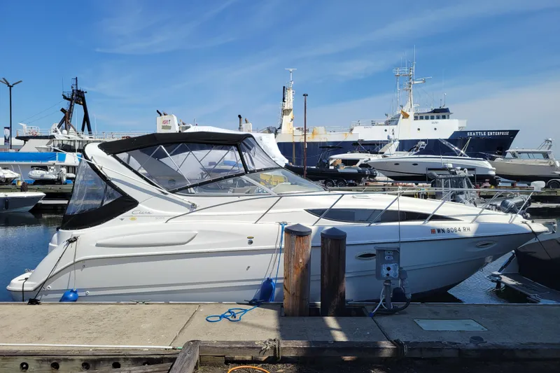 Slide: The Image of 1999 Bayliner 3055 Ciera Sunbridge docked at a marina under a clear blue sky. - 2