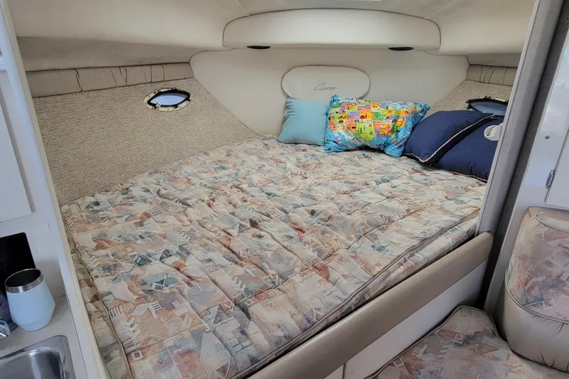 Slide: The Image of Cozy cabin interior of 1999 Bayliner 3055 Ciera Sunbridge with patterned bedding and colorful pillows. - 22