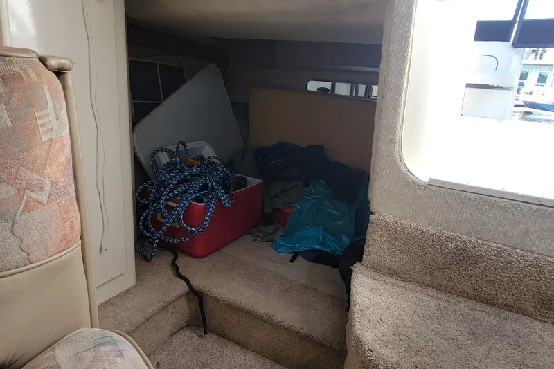 Slide: The Image of Interior of 1999 Bayliner 3055 Ciera Sunbridge with ropes and storage items. - 24