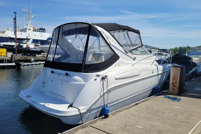 Slide: The Image of 1999 Bayliner 3055 Ciera Sunbridge docked at a marina under clear skies. - 3