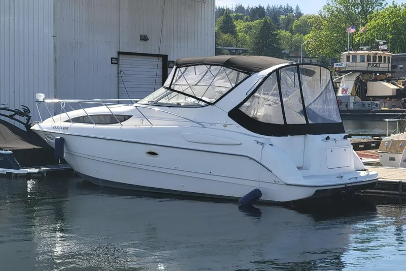 Slide: The Image of 1999 Bayliner 3055 Ciera Sunbridge docked at marina, featuring sleek design and covered cockpit. - 5