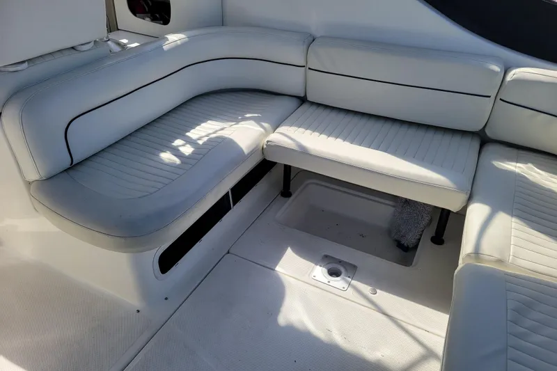 Slide: The Image of Interior seating of 1999 Bayliner 3055 Ciera Sunbridge boat, featuring white cushioned benches. - 9