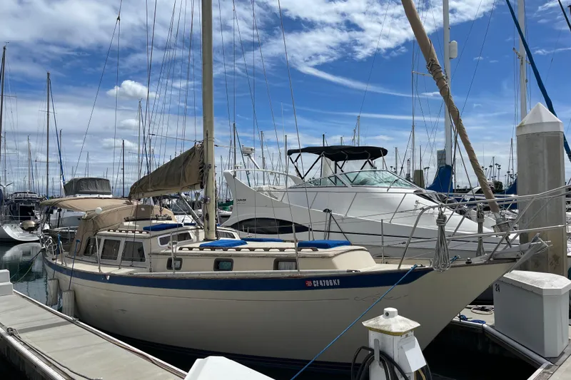 The Image of 1979 Islander Freeport sailboat docked at marina under blue sky. - 1