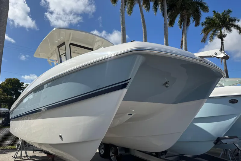 The Image of 2026 World Cat 235 TE boat under clear blue sky with palm trees. - 0