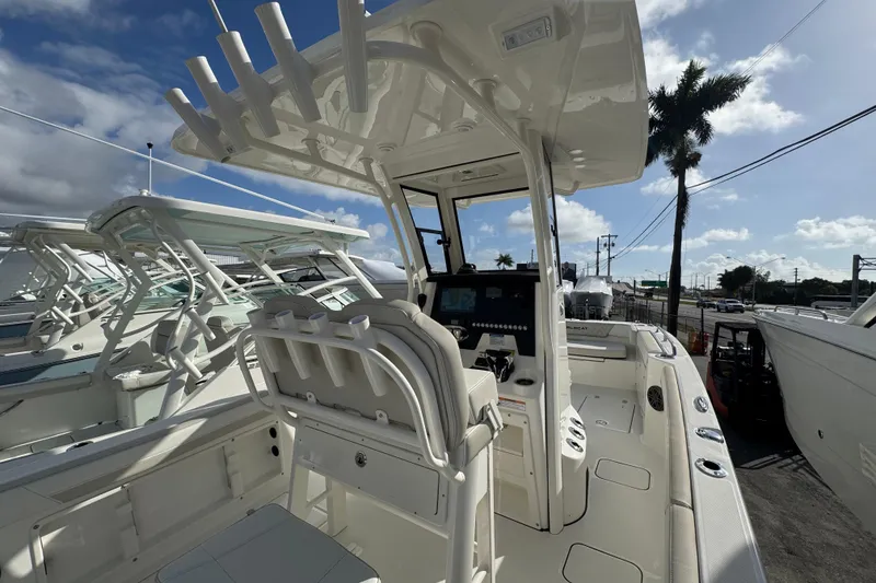 Slide: The Image of 2026 World Cat 235 TE boat interior with helm station and seating, under clear sky. - 6