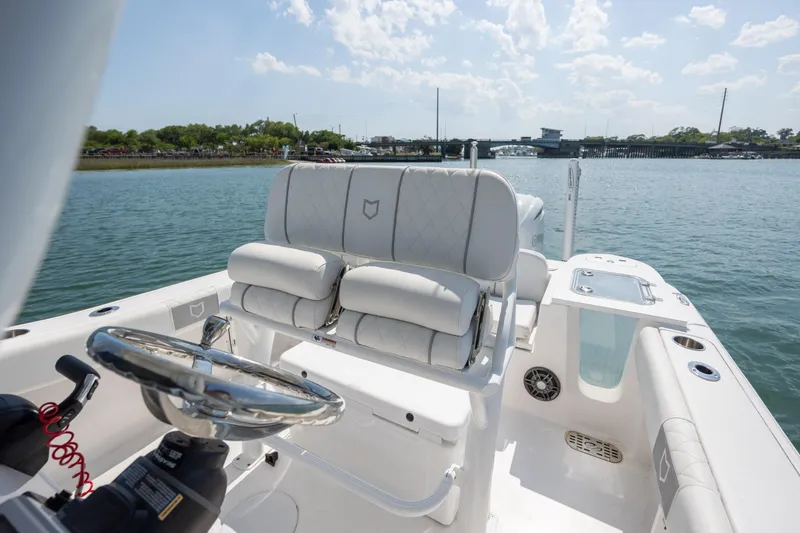 Slide: The Image of 2025 Sea Fox 228 Commander boat interior with steering wheel and cushioned seating. - 16